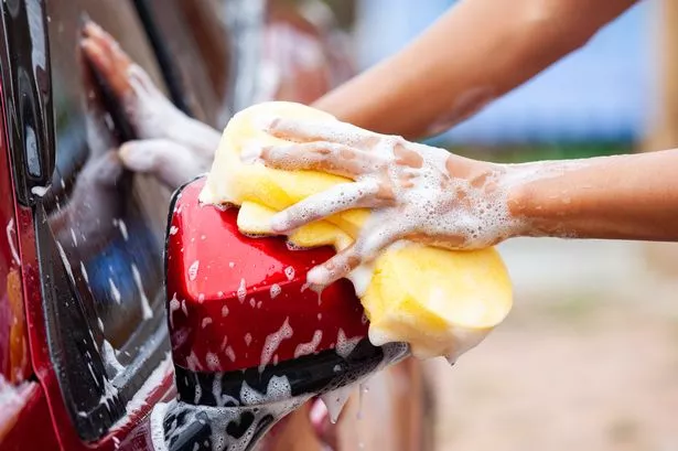 How To Protect Car Paint From Elements - person washing red car side mirror with yellow sponge