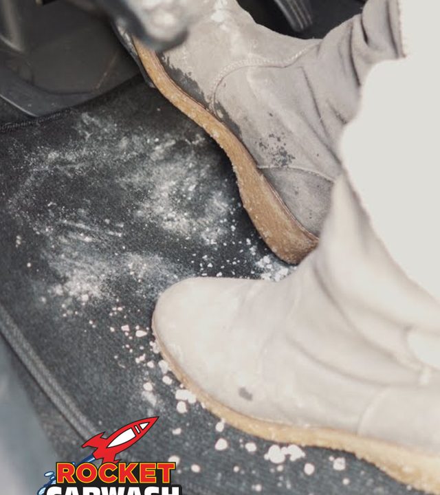 close up of someone wearing boots stepping on the gas pedal over a salt covered car mat