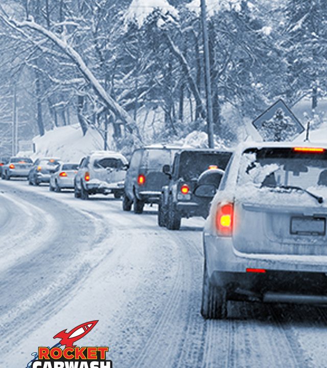 A row of cars driving on a snow covered road in winter
