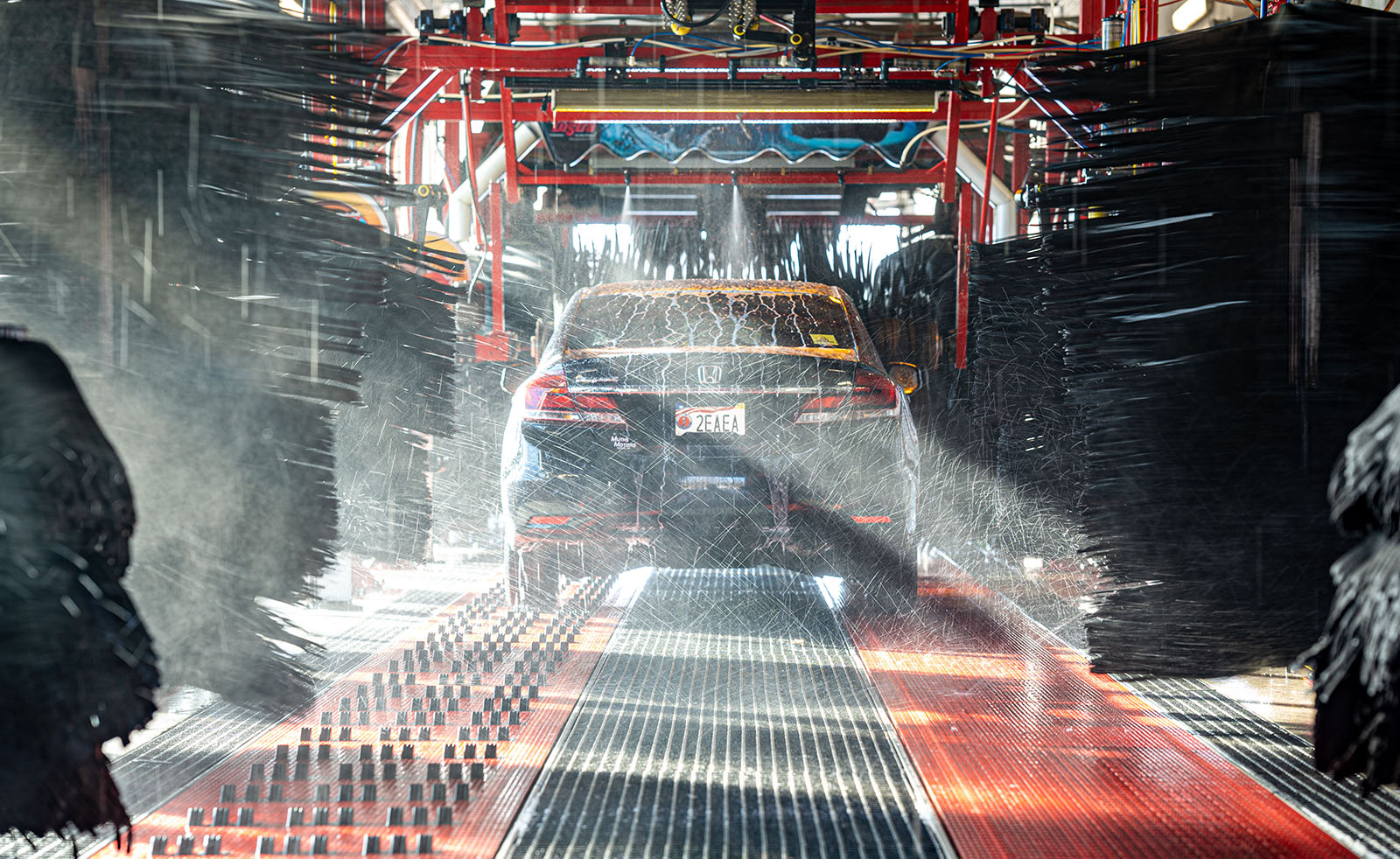 Why Car Washes Are Better For The Environment - black car going through Rocket Carwash