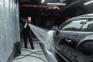 How to clean bird poop off your car window - Lady cleaning car with power washer